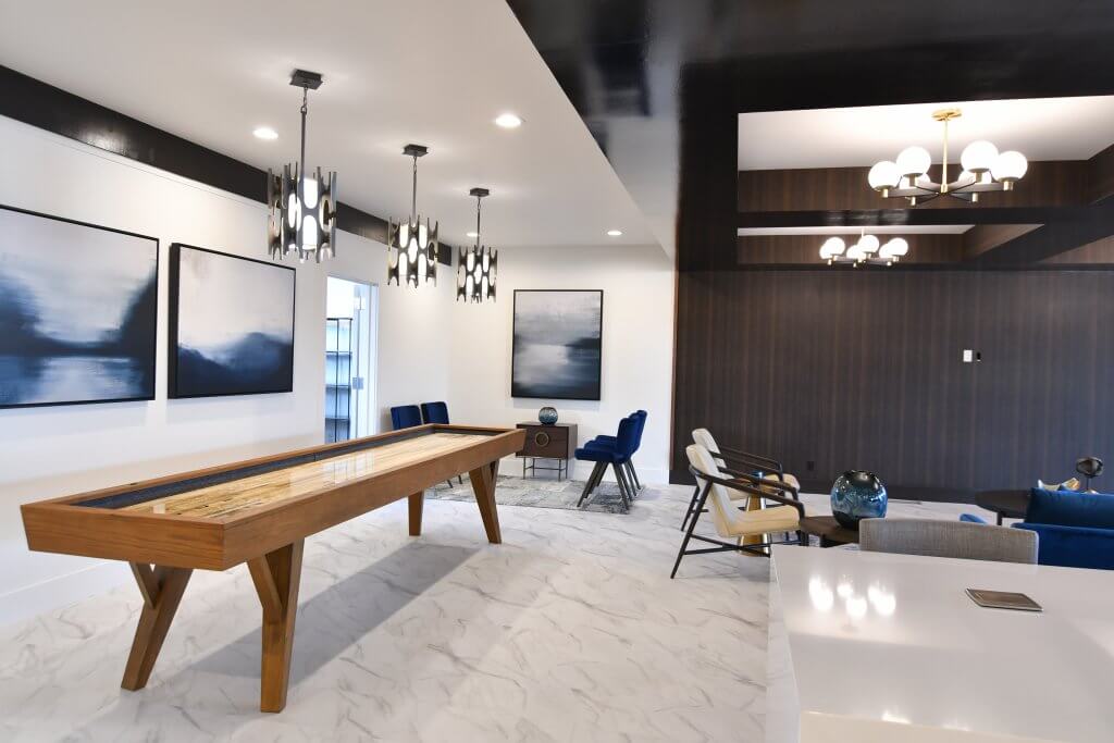 Community luxurious clubhouse with board games, lounge chairs and round tables.